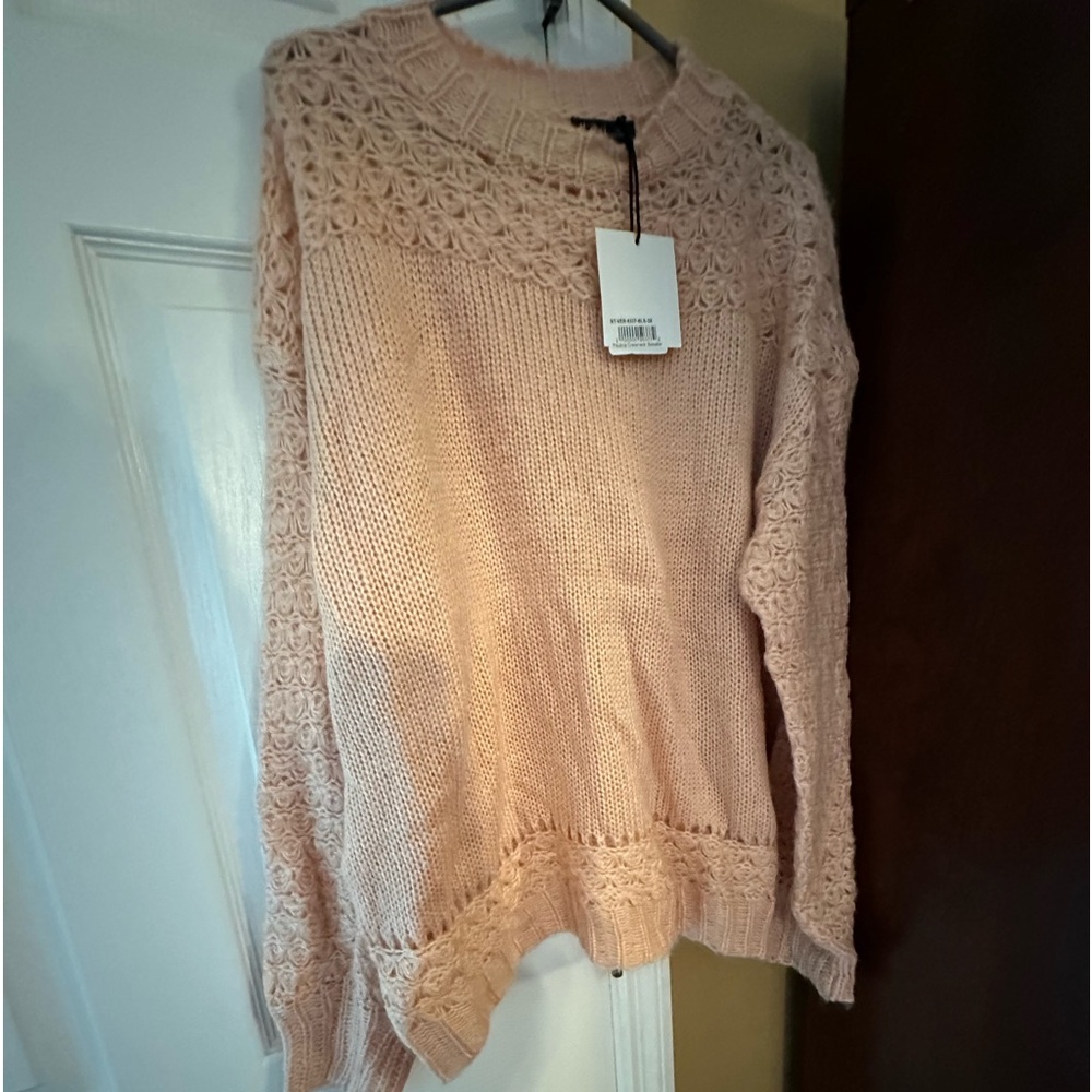 light pink sweater with see-through details around the top
